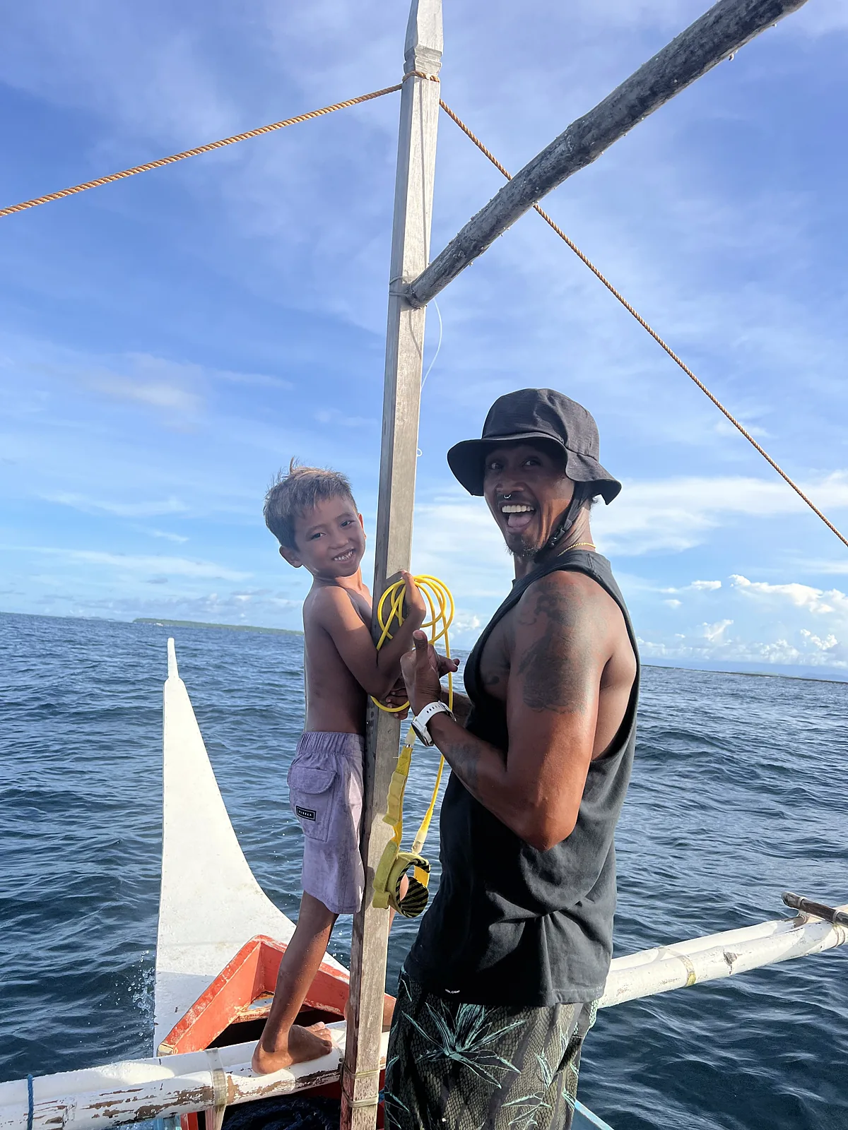 Coach and child on a traditional outrigger boat in Siargao
