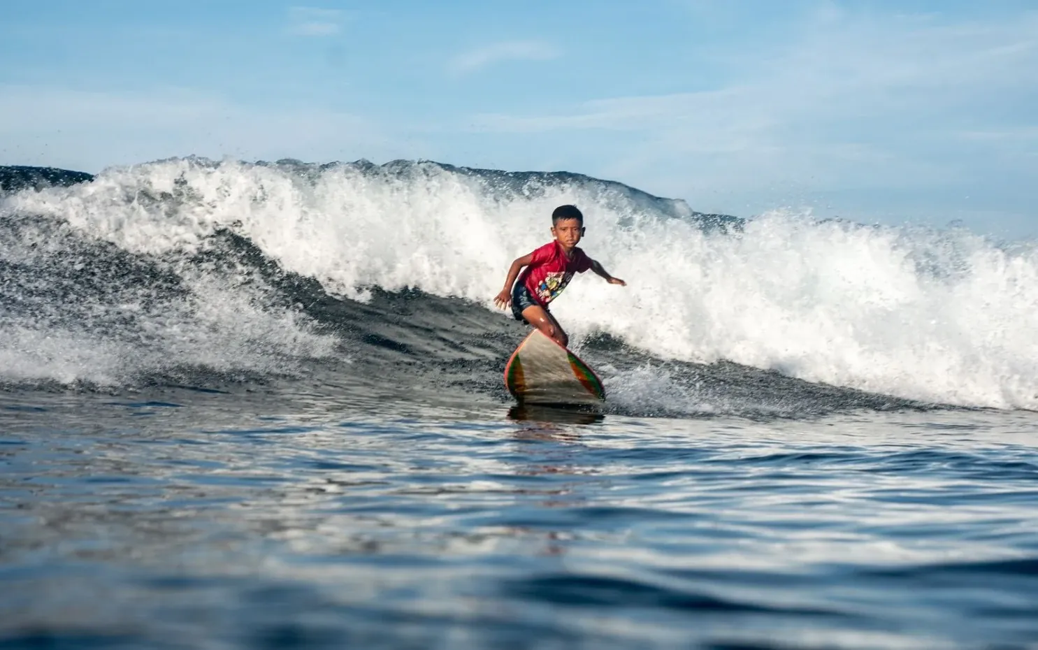 Young surfer riding a wave during a coaching session
